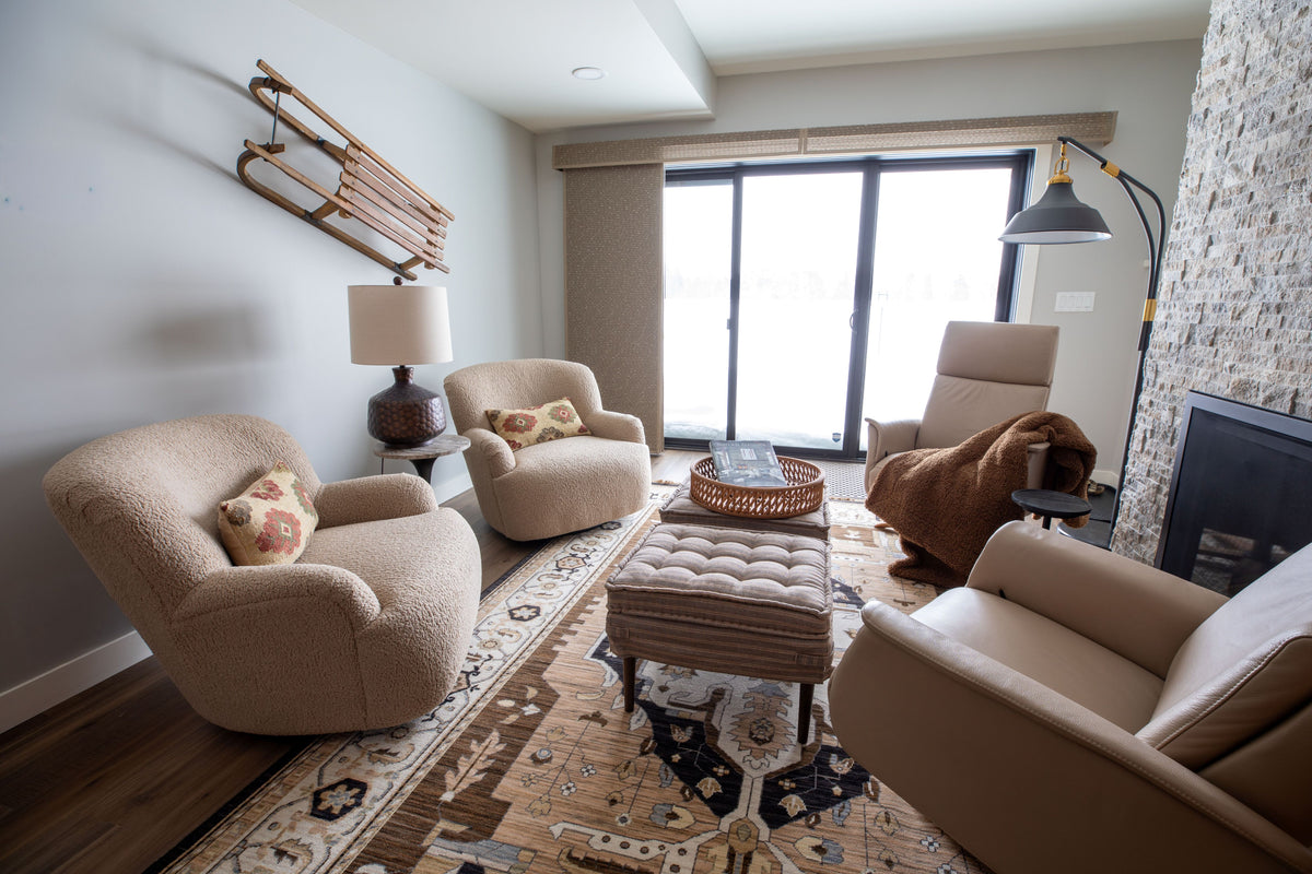 Mountain modern sitting room with cream swivel chairs and a vintage sled on the wall, Black Diamond project