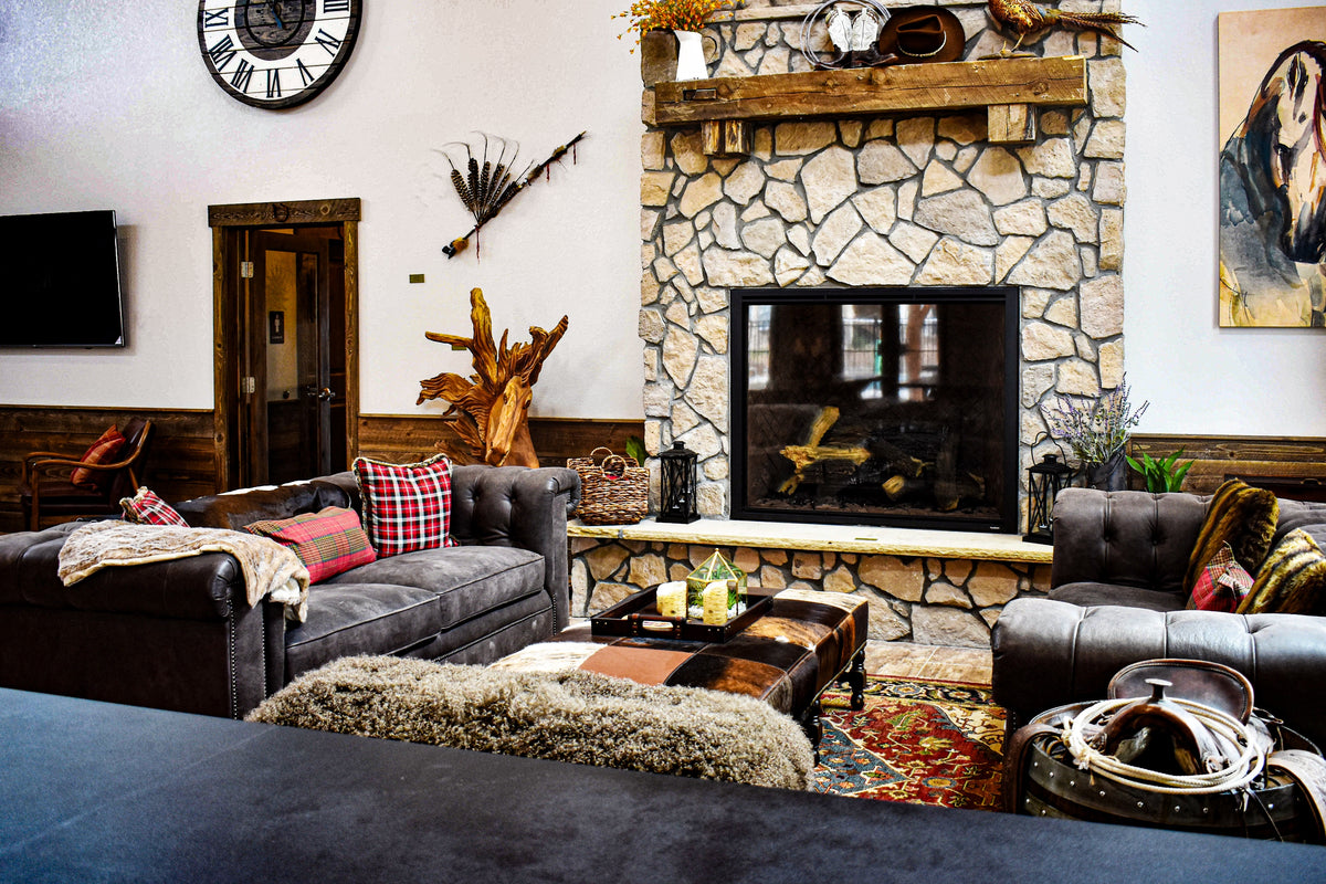 Western living room with leather sofas, stone fireplace, fur ottoman and horse art, Bucking Horse project, Northern Colorado
