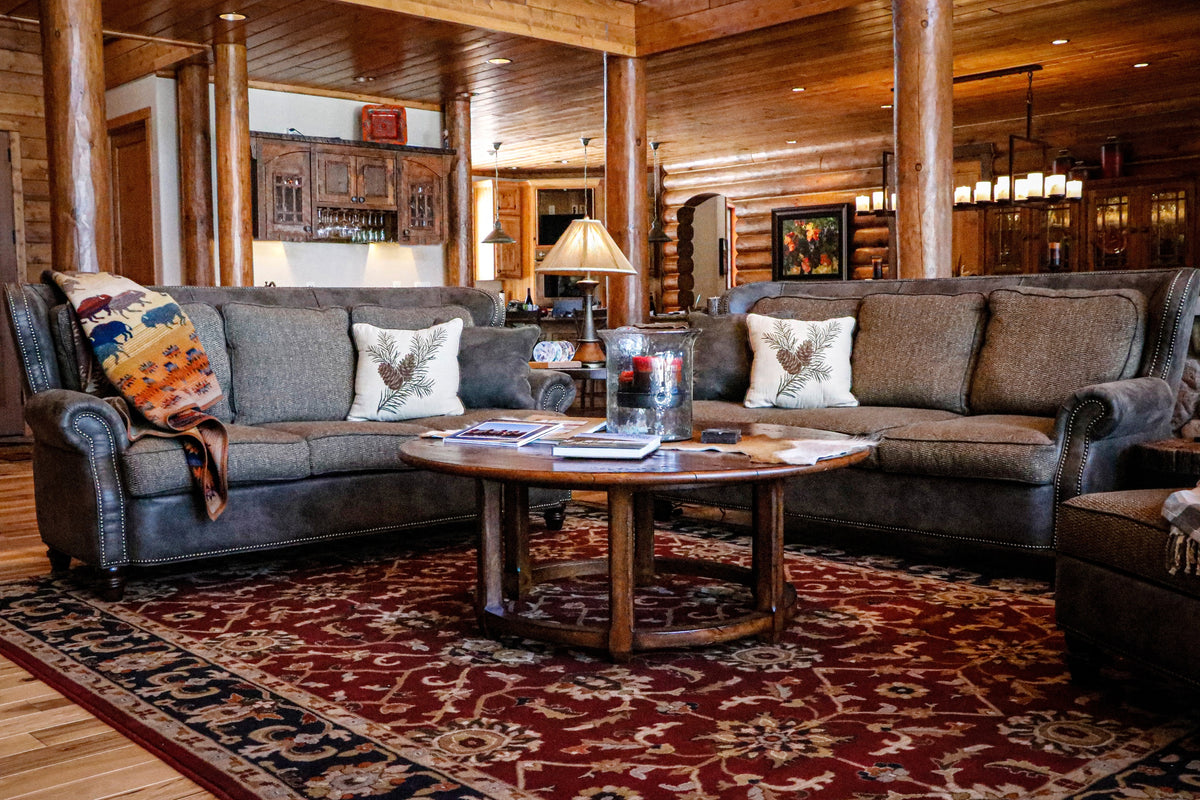 Log home living room with leather sofas and red area rug, Outdoorsman’s Oasis project, Northern Wisconsin