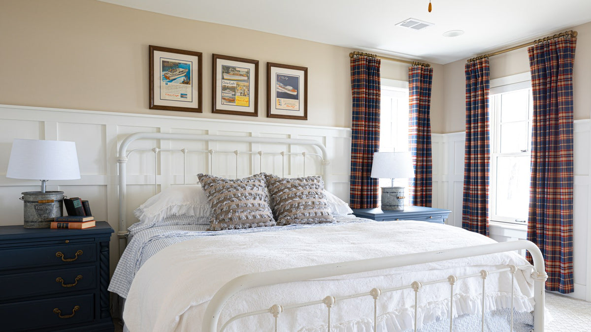 Bedroom with white iron bed, paneled wainscot, framed prints, plaid drapes and matching lamps, Duck Lake Landing project