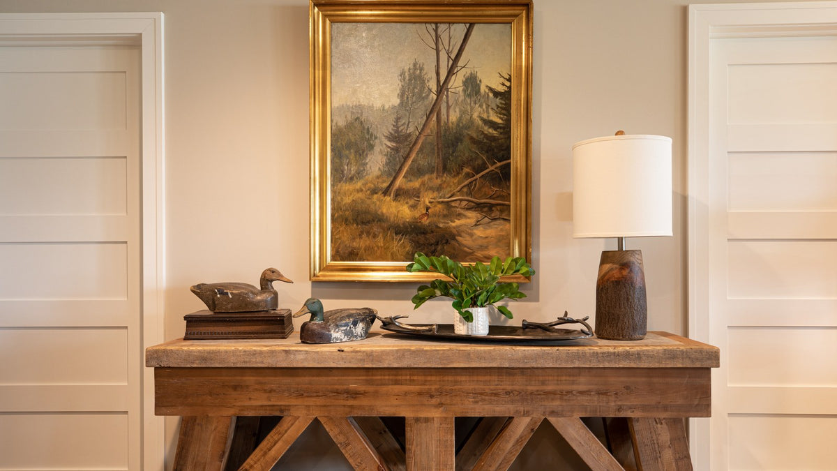 Gold-framed landscape over a trestle console with a lamp, between matching paneled doors, Duck Lake Landing project