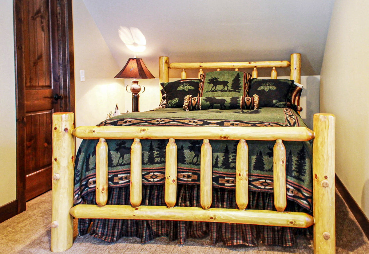 Bedroom with peeled-log bed and patterned bedding, Grand Haven Lodge project, Lake Tomahawk, WI