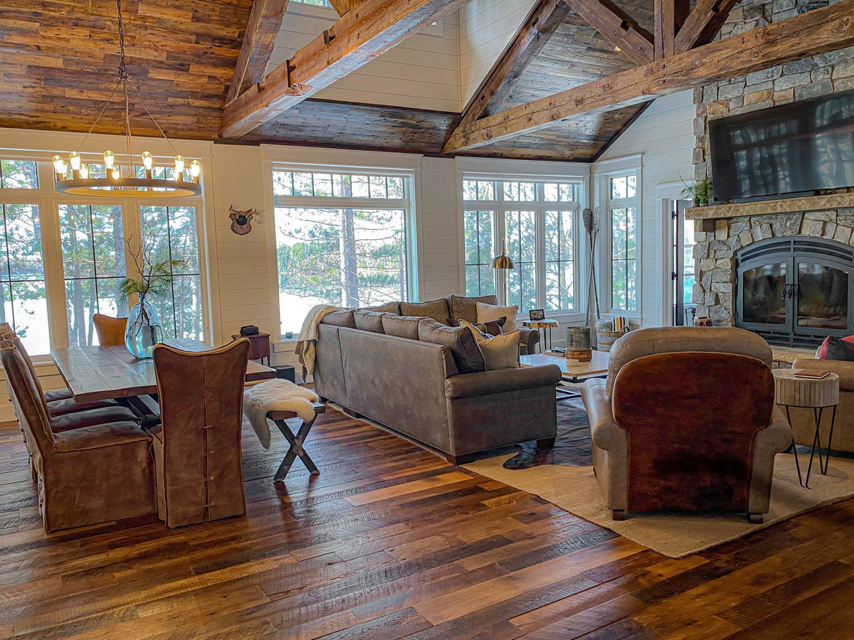 Open great room with a vaulted wood ceiling, leather chairs and tall lake windows, Dreamer's Lake project, Central Wisconsin