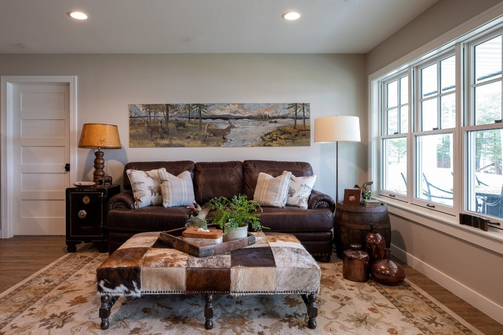 Bright lake-home sitting room with a leather ottoman and white window trim, Duck Lake Landing project, Eagle River, Wisconsin