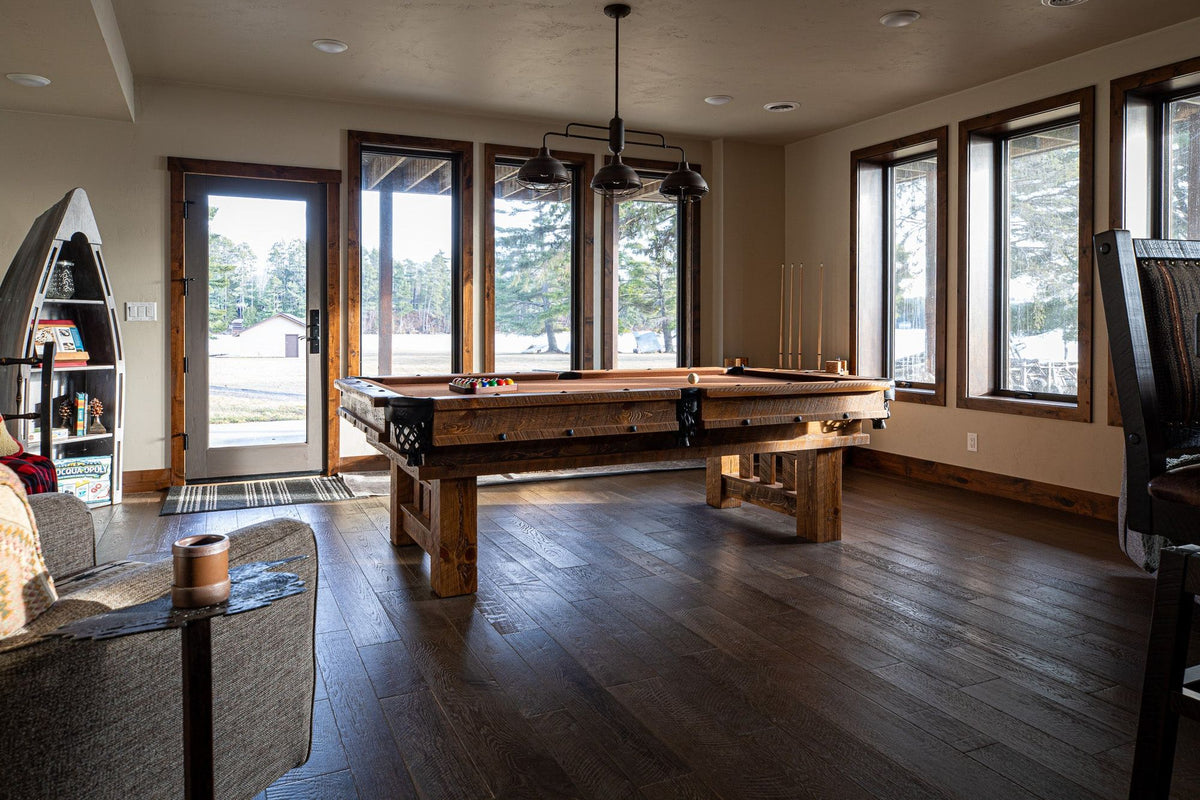 Game room with a pool table, dark wood floors and a row of tall windows, Timberline project, Northern Wisconsin