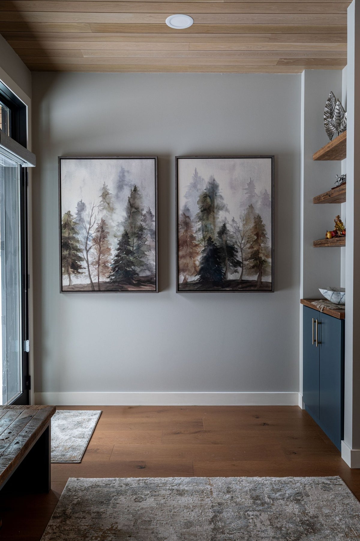 Entry hall with a wood-plank ceiling, a black door frame and a pair of forest prints, Black Diamond project
