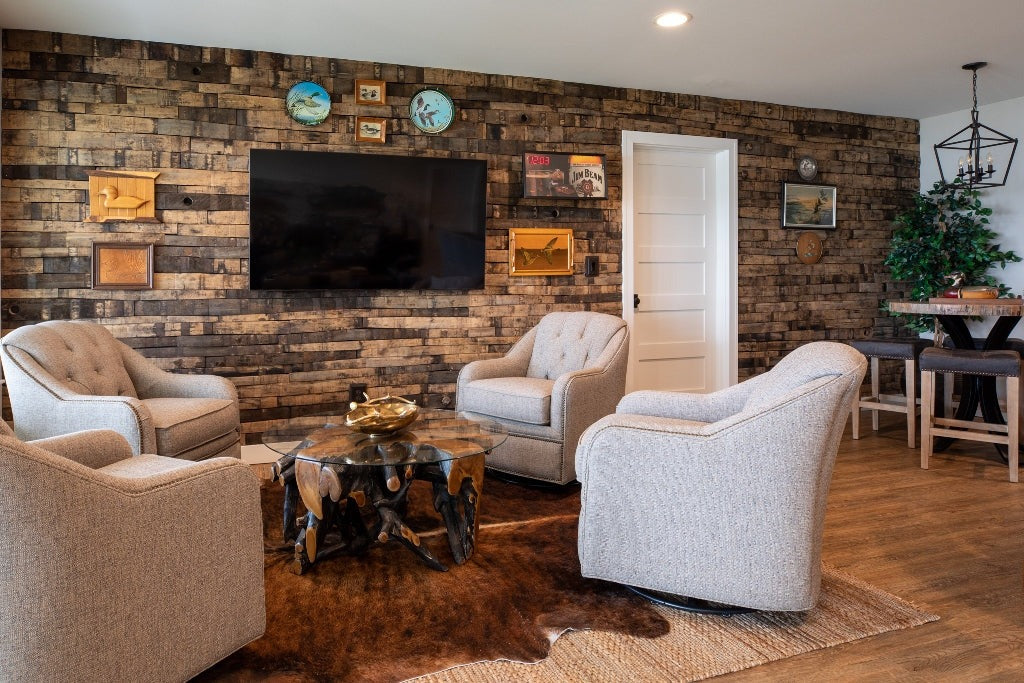 Living room with a wood-plank wall, tweed swivel chairs and a cowhide rug, Duck Lake Landing project, Eagle River, Wisconsin