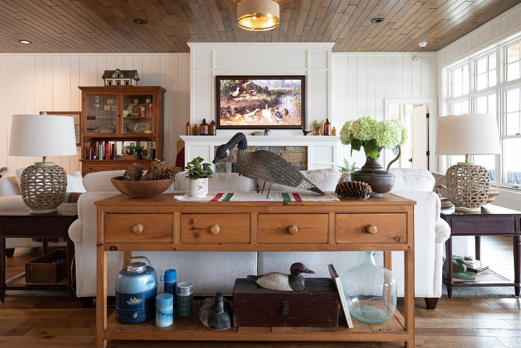 Pine console with duck decoys behind a white sofa facing a fireplace, Duck Lake Landing project, Eagle River, Wisconsin