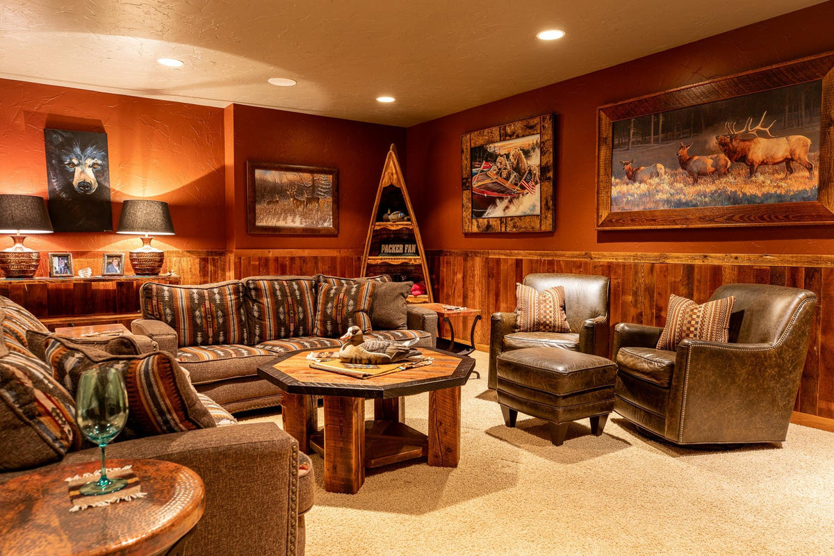 Family room with Southwest-pattern sofas, leather armchairs and an octagonal wood table under wildlife art, Big Hills project