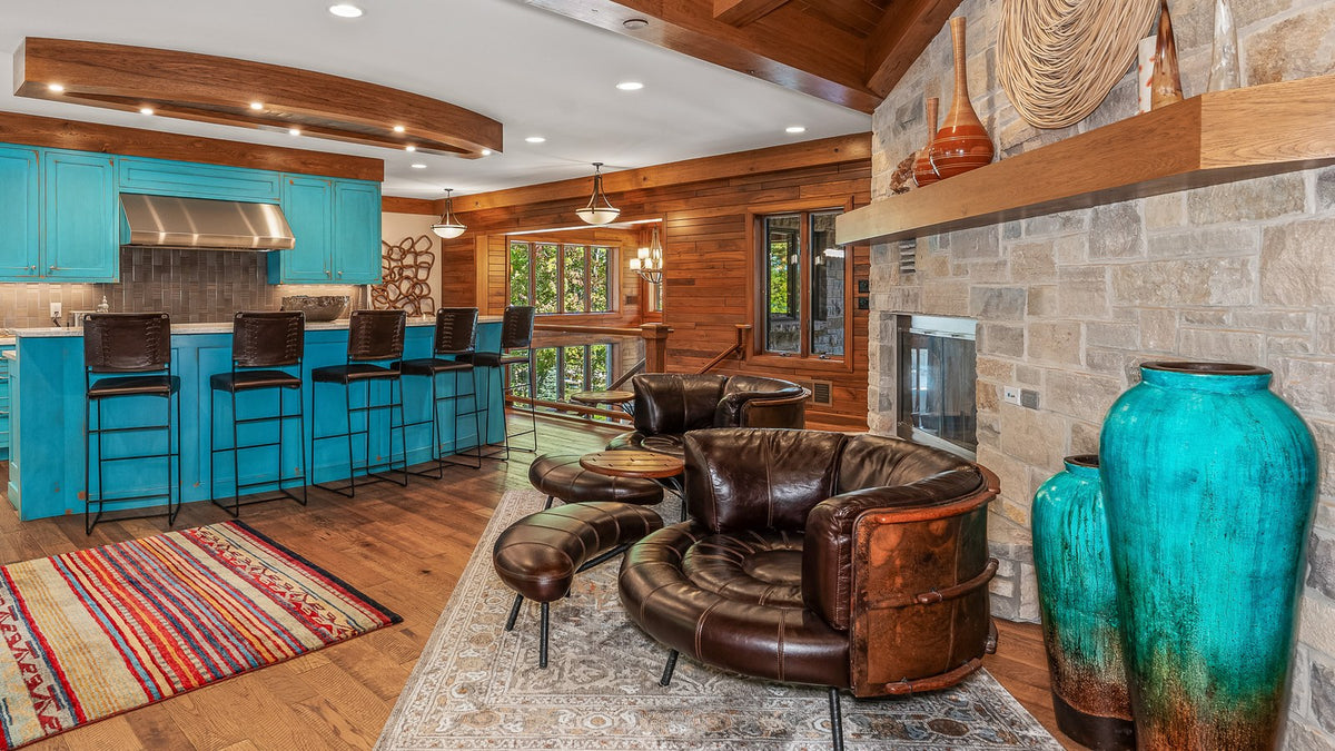 Turquoise cabinets, large turquoise pottery jars, a striped kilim runner and leather chairs