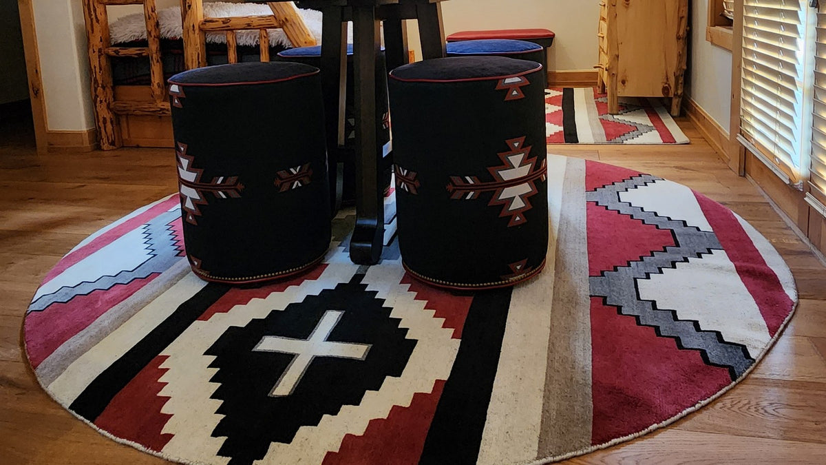 Round red, black and white Navajo-style rug with leather ottomans
